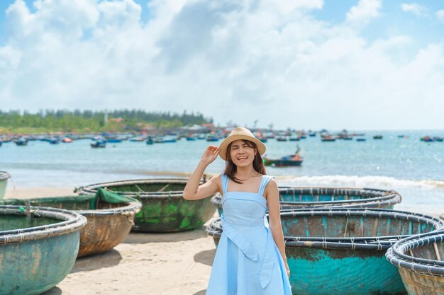 Viajante de mulher visitando a praia de My Khe e cesta de turismo terminando barcos Turista com vestido azul e chapéu viajando na cidade de Da Nang, Vietnã e conceito de viagem no Sudeste Asiático