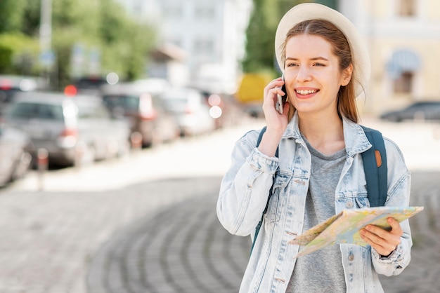 Viajante de tiro médio com mapa e telefone celular