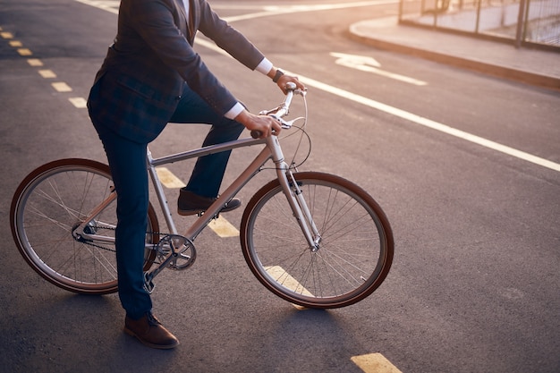 Viajante em traje formal andando de bicicleta na rua