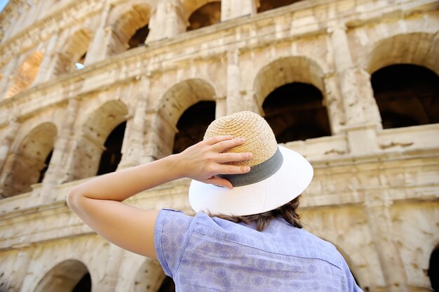 Viajante fêmea novo que olha em famoso o Colosseum em Roma.