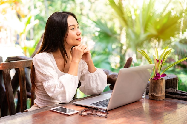 Viajante freelancer jovem trabalhando online usando laptop enquanto viaja de férias conceito freelance