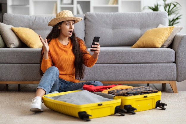 Viajante jovem chocada olhando para o interior da tela do telefone