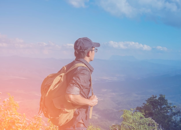 Viajante jovem com mapa mochila relaxante ao ar livre com montanhas rochosas no fundo Férias de verão e conceito de treino de estilo de vida