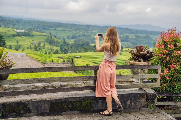 Viajante jovem em belos terraços de arroz Jatiluwih no contexto de famosos vulcões em Bali, Indonésia.