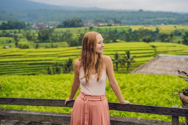 Viajante jovem em belos terraços de arroz Jatiluwih no contexto de famosos vulcões em Bali, Indonésia.