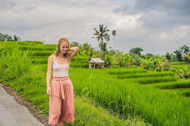 Viajante jovem em belos terraços de arroz Jatiluwih no contexto de famosos vulcões em Bali, Indonésia.