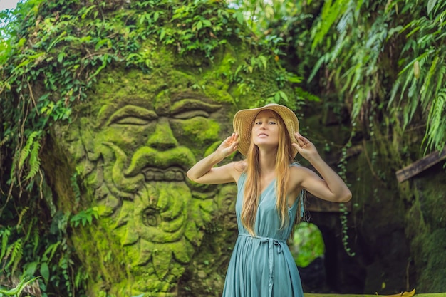 Viajante jovem em um jardim balinês coberto de musgo Viajar para o conceito de Bali