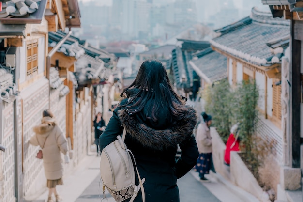 Foto viajante jovem mulher asiática com mochila viajando para a arquitetura de estilo tradicional coreano