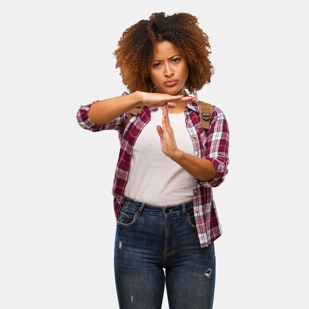 Viajante jovem mulher negra fazendo um gesto de timeout