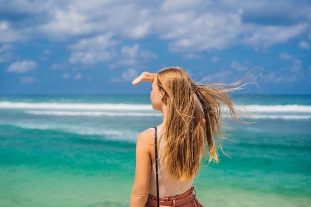 Viajante jovem na incrível melasti beach com água turquesa bali island indonésia