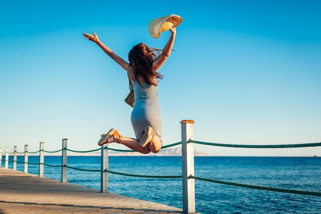 Viajante jovem se sentindo feliz e livre no cais nas férias de verão do Mar Vermelho