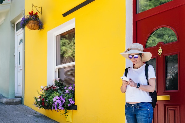 Foto viajante loira pronta para explorar o mundo chirpy chic e carismático na yellow house com bate-papo móvel