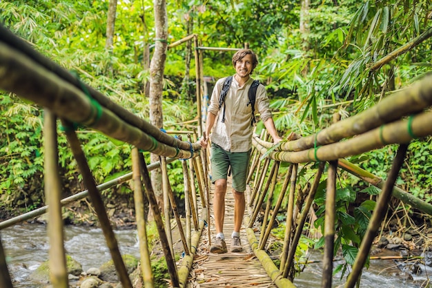 Viajante masculino na ponte suspensa em Bali