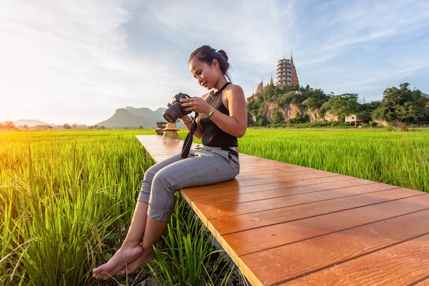 Viajante mulher asiática tirar uma foto e desfrutando no wat tham suea