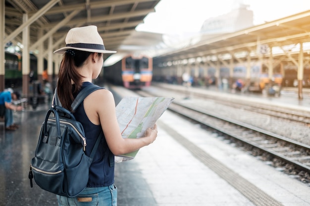 viajante mulher olhando mapa enquanto espera por trem na plataforma ferroviária, Bangkok, Thailad