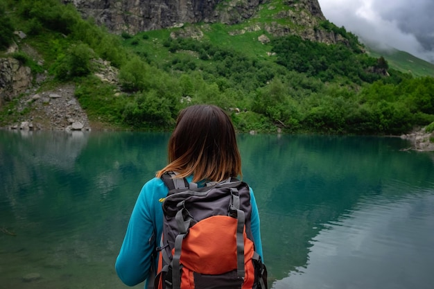 Viajante olha para o lago de montanha viagem e conceito de vida ativa