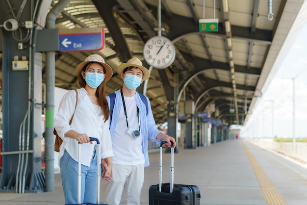 Viajantes asiáticos casal esperando trem na estação de trem em Bangkok, Tailândia, conceito de viagem e transporte