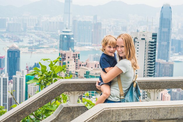 Viajantes de mãe e filho no pico de Victoria contra o pano de fundo de Hong Kong. Viajar com o conceito de crianças.