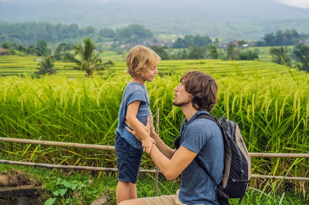 Viajantes de pai e filho em belos terraços de arroz Jatiluwih no contexto de famosos vulcões em Bali, Indonésia Viajando com o conceito de crianças