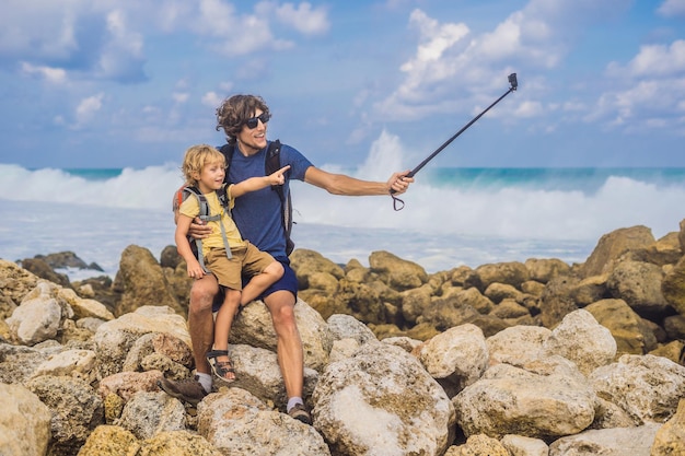 Viajantes de pai e filho na incrível Melasti Beach com água azul-turquesa, Bali Island Indonésia. Viajar com o conceito de crianças