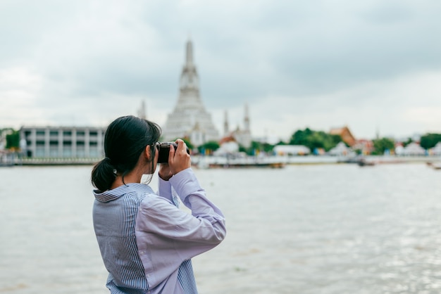 Viajantes de solo de mulher asiática e tirar foto antigos edifícios de pagode