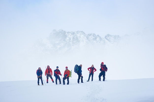 Viajantes em pé no campo nevado nas montanhas