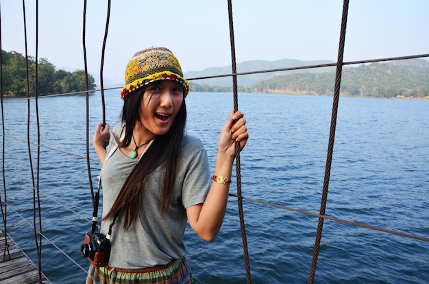 Viajantes mulheres tailandesas fotógrafas visitam e posam retratos tiram fotos na ponte suspensa de madeira cruzando o lago para a ilha na represa de Kaeng Krachan e no Parque Nacional em Phetchaburi Tailândia