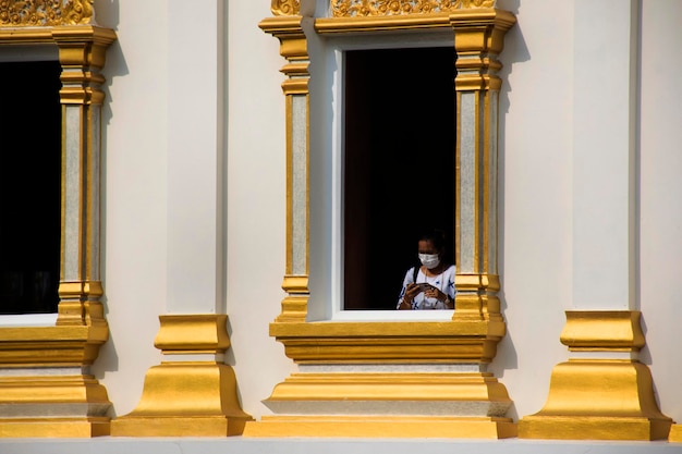 Viajantes mulheres tailandesas viajam visitam e respeitam orando bênção de buda adoração sagrada na arquitetura antiga edifício antigo igreja ubosot branca no templo Wat Tanot em Nonthaburi Tailândia