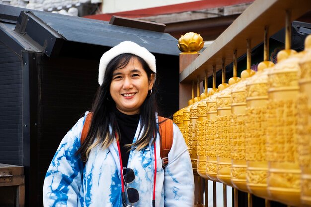 Viajantes mulheres tailandesas visitam e rito giram com rodas de oração para orar abençoando o mistério do santo desejo no templo de Sanbangsa na cidade de Seogwipo em 18 de fevereiro de 2023 na ilha de Jeju, Coreia do Sul