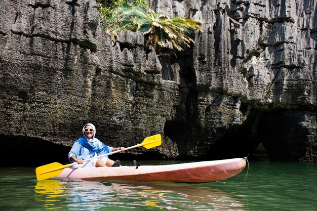 Viajantes tailandesas remo canoa de barco de viagem local no mar visitam a ilha de pedra Ko Khao Yai e Prasat Hin Pan Yod no Parque Nacional Mu Ko Petra em Pak Bara em La ngu de Satun Tailândia