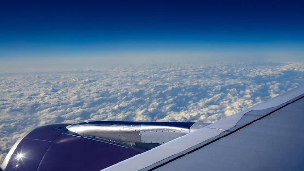 Viajar por aire Turbina y ala de avión en viaje de vuelo con hermoso cielo Hermosas nubes desde arriba como se ve a través de la ventana del avión Vista del viajero en cabina