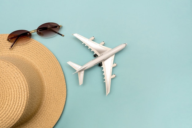 Viajar en avión. Disposición sobre un fondo azul. Sombrero, avión, gafas. Endecha plana.