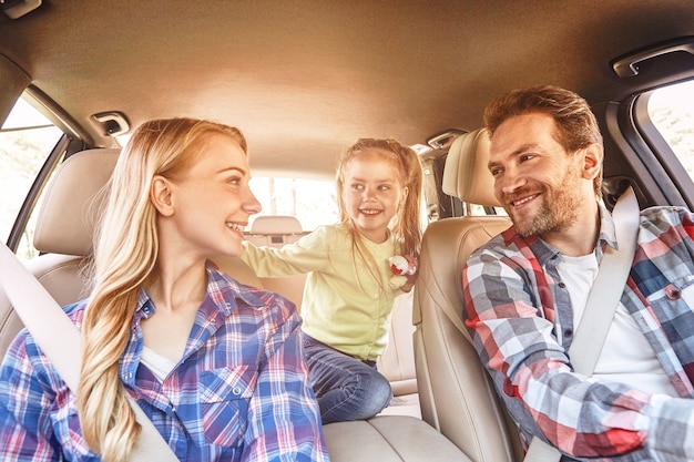 Viajar é viver uma família sorridente, sentada no carro e dirigindo pela estrada da família