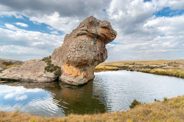 Viajar a Lesotho Un extraño bloque de roca oblicua sobre un estanque en el parque nacional de Sehlabathebe