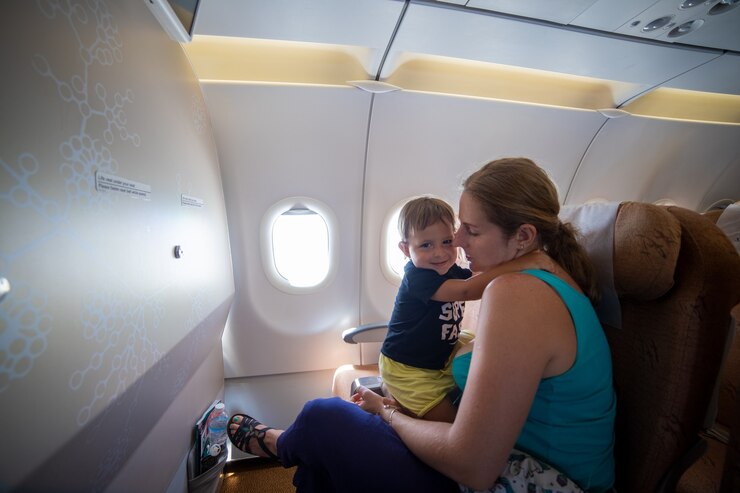 viajar con un niño. lindo niño abraza a mamá mientras está sentado en el asiento del pasajero del avión.