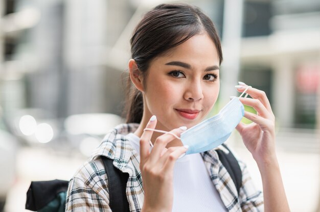 Viajar sola joven asiática hermosa de vacaciones con el virus de la máscara de protección.