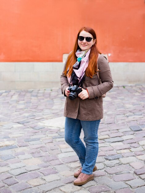 Viajar turista mujer con cámara, estilo chica pelirroja con gafas de sol