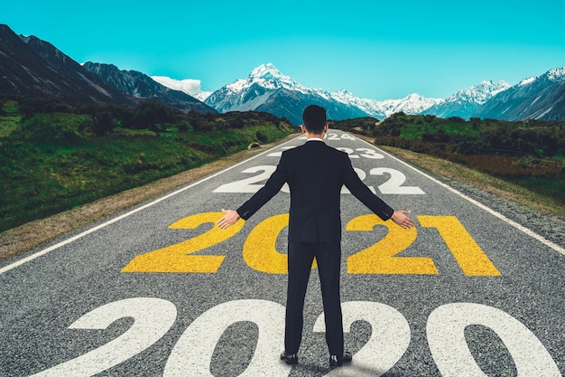 Foto el viaje del año nuevo 2021 y el concepto de visión futura. hombre de negocios viajando por la carretera que conduce a la celebración del feliz año nuevo a principios de 2021 para un comienzo nuevo y exitoso.