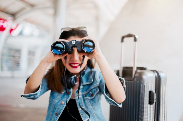 viaje asimiento asiático de la muchacha binocular con el fondo del concepto de viaje céntrico de la ciudad