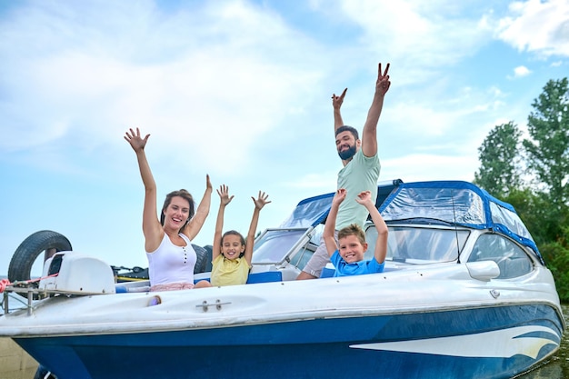 Un viaje en barco. Una linda familia haciendo un viaje en barco y luciendo alegre