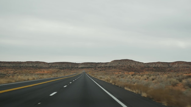 Viaje por carretera al Gran Cañón, Arizona, EE. UU., Conduciendo en automóvil desde Utah. Ruta 89. Autoestop viajando en América, viaje local, ambiente tranquilo del salvaje oeste de tierras indias. Vista de la carretera a través del parabrisas del coche.