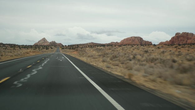 Viaje por carretera al Gran Cañón, Arizona, EE. UU., Conduciendo en automóvil desde Utah. Ruta 89. Autoestop viajando en América, viaje local, ambiente tranquilo del salvaje oeste de tierras indias. Vista de la carretera a través del parabrisas del coche.