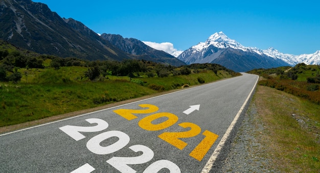 Viaje por carretera de año nuevo 2021 y concepto de visión futura. Paisaje natural con carretera que conduce a la celebración del feliz año nuevo a principios de 2021 para un comienzo fresco y exitoso.