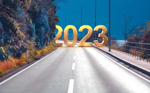 Viaje por carretera de Año Nuevo 2023 y concepto de visión futura 2023 con carretera que conduce a la celebración de feliz año nuevo a principios de 2023 para un comienzo exitoso