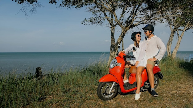 Viaje por carretera en scooter Pareja de amor en moto roja con ropa blanca en el sendero del camino forestal