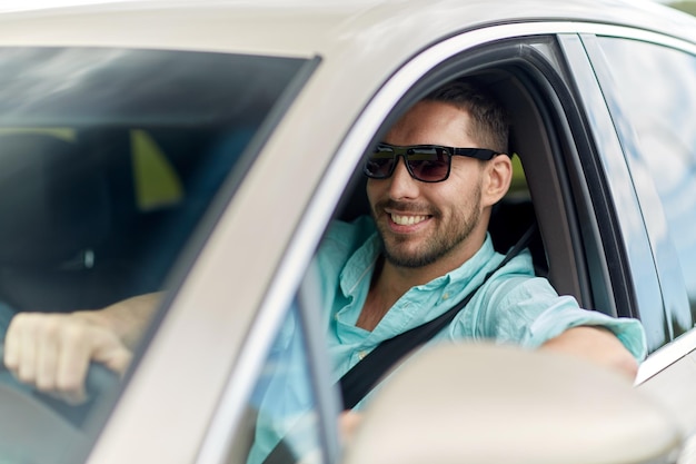 viaje por carretera, transporte, viajes y concepto de personas - hombre sonriente feliz con gafas de sol conduciendo camión