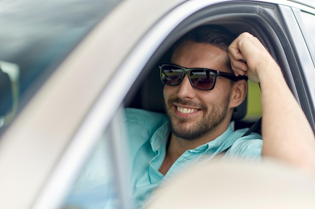 viaje por carretera, transporte, viajes y concepto de personas - hombre sonriente feliz con gafas de sol conduciendo camión