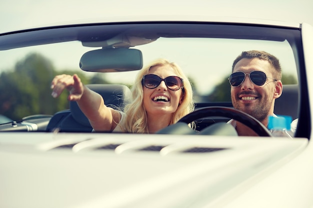 viaje por carretera, viajes, pareja y concepto de personas - hombre y mujer felices conduciendo en un camión cabriolet al aire libre