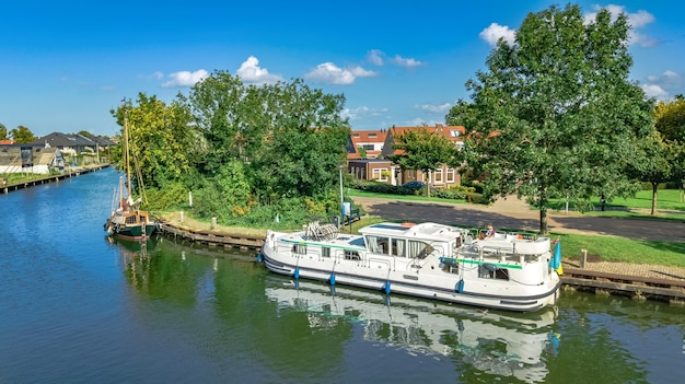 Viaje en casa flotante en canal en el típico pueblo holandés en el campo, vacaciones en crucero en Holanda