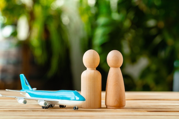 Viaje familiar y concepto de vacaciones. Figuras de madera del avión familiar y de juguete